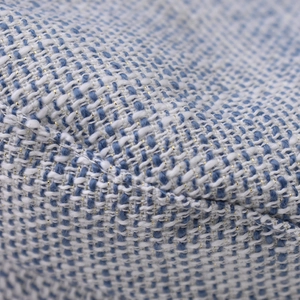 Nahaufnahme von blau-weißem Tweedstoff mit glänzenden goldenen Metallfäden