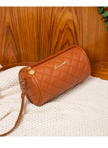 Detailed view of a brown quilted cylinder bag with gold hardware on a knit surface