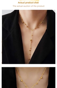 Detail of 18K gold-plated Y-shaped drop necklace with spherical beads on a model