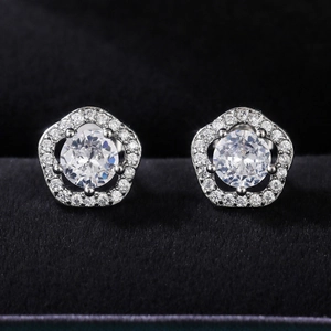 Detailed macro view of silver flower stud earrings with sparkling cubic zirconia stones