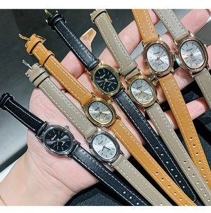 Close-up of vintage oval quartz watches with diverse leather straps in various colors