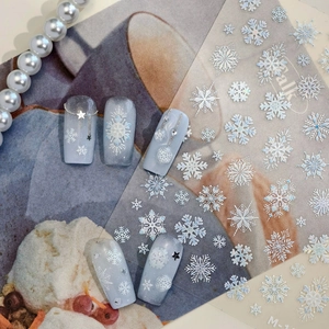 Winter snowflake nail art stickers with white and silver 3D embossed designs for manicures