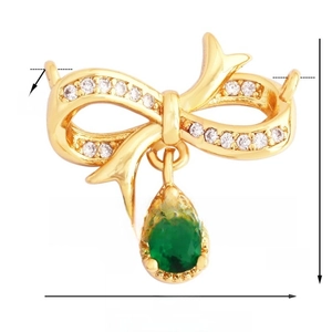 Vue macro détaillée d'un pendentif nœud doré avec une pierre verte et des mesures