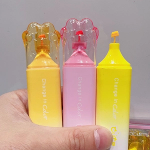 Cute cat paw highlighters in pastel yellow, pink, and orange held in hand for stationery