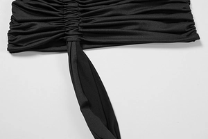 Detail view of black ruched fabric featuring horizontal pleats and a wide hanging sash