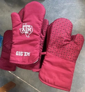 Detail of maroon silicone heat-resistant oven mitts with non-slip texture and logo
