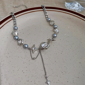 Detail of silver star necklace with blue faux pearls and star charms on ceramic plate