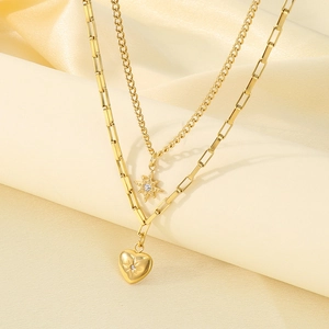 Detailed view of gold-layered necklace featuring heart and star pendants with rhinestones