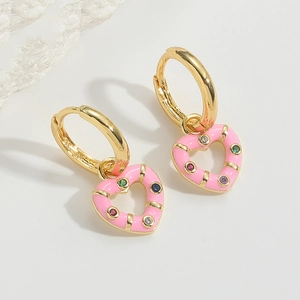 Detailed macro view of heart earrings with colorful zircon stones on white lace background