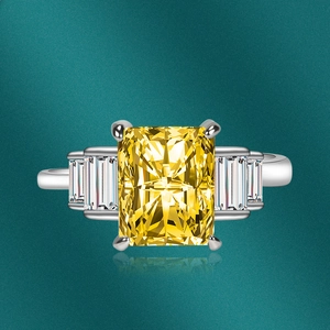 Macro shot of a luxury rectangle yellow zircon ring with side baguette stones on green