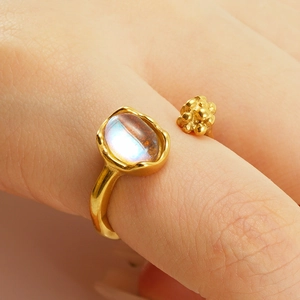 Macro detail of gold irregular moonstone ring with molten texture on hand