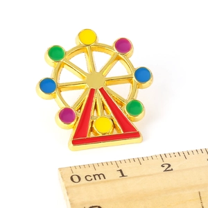 Detail of colorful Ferris wheel enamel brooch in gold plating with vibrant dabs of paint