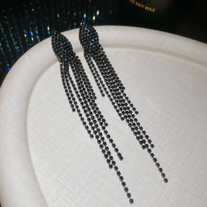 Detailed close-up of long black jellyfish tassel earrings with sparkling zircon stones