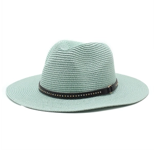Detail of mint green straw hat with black leather rivet band on white background