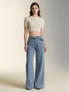 Détail d'un jean taille haute à jambe large avec un crop top en maille côtelée beige