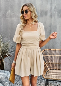 Detail view of beige square neck romper featuring puff sleeves and pleated waist design