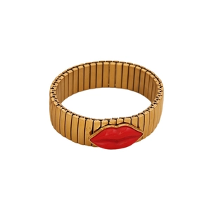 Lip-shaped gold elastic bracelet featuring a vibrant red lip charm and metal band
