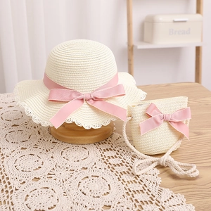 Détails d'un ensemble chapeau de paille et sac enfant avec nœuds roses et dentelle