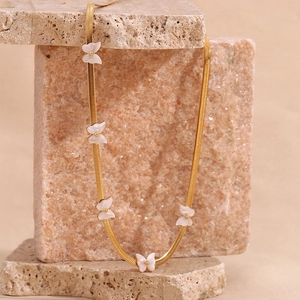 Detail of 18K gold-plated blade chain with delicate white shell butterfly charms