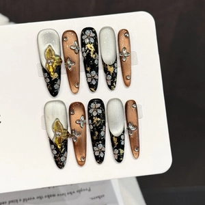 Handmade press-on nails with black butterfly floral patterns and gold foil accents