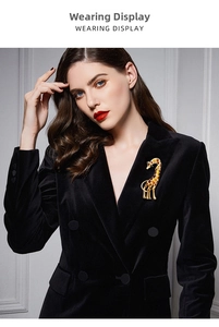 Detailed close-up of an enamel giraffe brooch worn on a classic black velvet blazer jacket