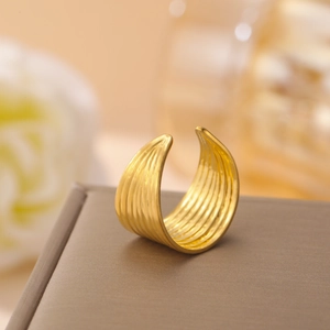Macro detail of textured 18K gold plated stainless steel ring with elegant curved grooves
