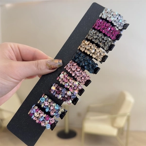 Gros plan de pinces à cheveux en strass colorés sur une carte pour filles
