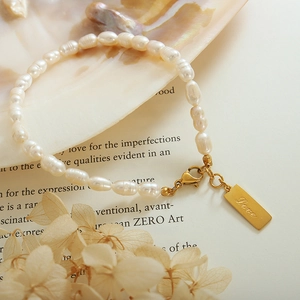 18K gold plated titanium steel pearl bracelet featuring a rectangular Love tag pendant