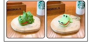 Detail view of green dinosaur and crocodile biting finger toys with gold keychains
