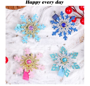 Detail view of 4-piece glitter snowflake hair clips with colorful rhinestones on snow