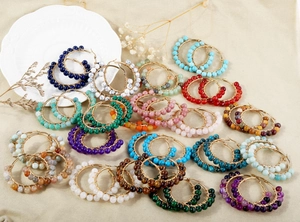 Detailed view of handmade gold wire-wrapped hoop earrings with natural turquoise beads