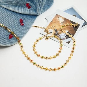 Detailed view of gold necklace featuring colorful floral links and lobster clasp closure