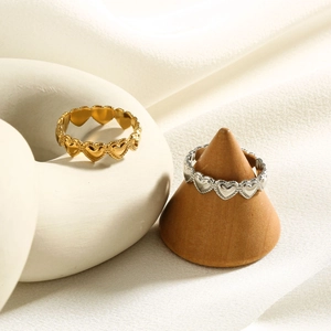Detailed close-up of heart-shaped titanium steel rings in gold and silver finish