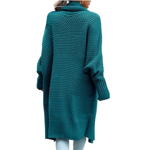 Detail of teal chunky knit cardigan featuring oversized batwing sleeves and long silhouette