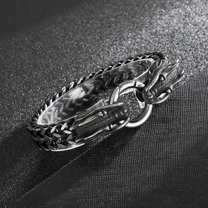 Macro detail of retro steel dragon head clasp and intricate woven metal chain links