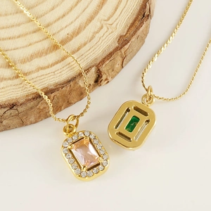 Détails macro de colliers plaqués or 18 carats avec pendentifs en zircon rose et vert