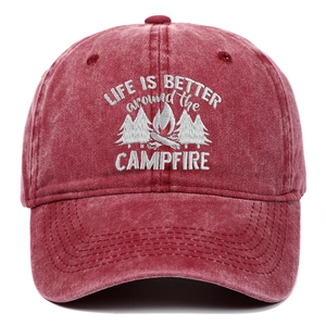 Close-up of white embroidery detail on a washed red cotton camping baseball cap