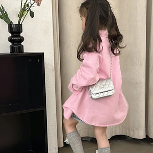 Girl in pink shirt wearing silver quilted crossbody bag with star decoration
