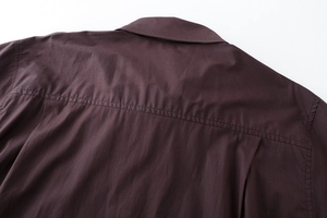 Detail of dark brown cotton poplin shirt featuring double-stitched back yoke and collar
