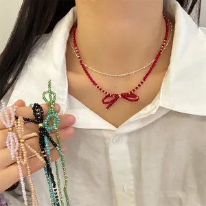 Handmade double-layered faceted bead necklace with a bow pendant in vibrant red and gold