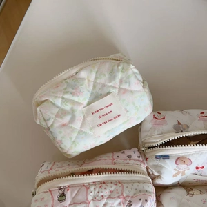 Macro detail of quilted cosmetic bags with floral, bunny, and bear cartoon prints