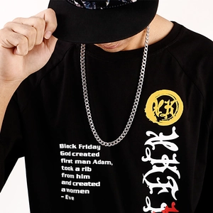 Gros plan d'une chaîne NK en acier inoxydable hip-hop portée avec un sweat noir à motifs
