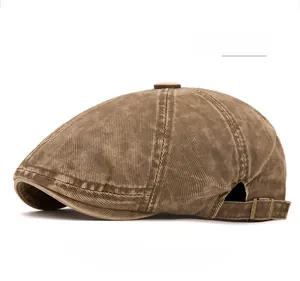 Detail of coffee brown corduroy beret hat featuring metal adjustable side buckles