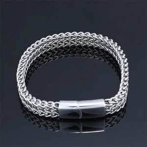 Macro detail of men's stainless steel wheat chain bracelet with cylindrical clasp