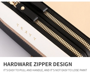 Detail of golden hardware zipper and textured leather on tricolor patchwork wallet