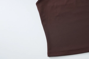 Detail aus dunkelkaffeebraunem Strick mit strapazierfähiger Doppelnaht am Saum des Tops