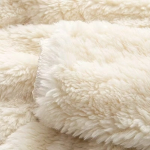 Close-up of soft white fuzzy faux fur texture on a warm hooded short jacket