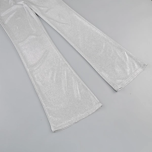 Detailed view of silver sequin fabric on flared trousers with metallic shimmer finish