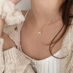 Elegant 925 sterling silver bow pendant necklace with minimalist snake chain on model