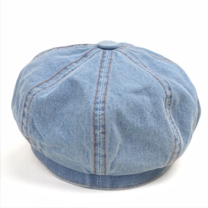 Detail of light blue denim newsboy cap with vintage stitching and paneled design